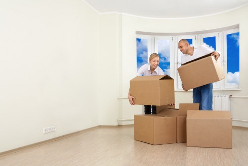Staff member carrying boxed items using safe lifting techniques during a local van move